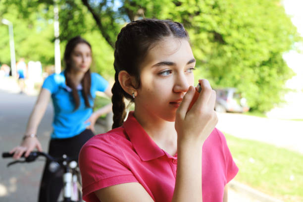 istock Girl having asthma using asthma inhaler while riding a bike 1224954097