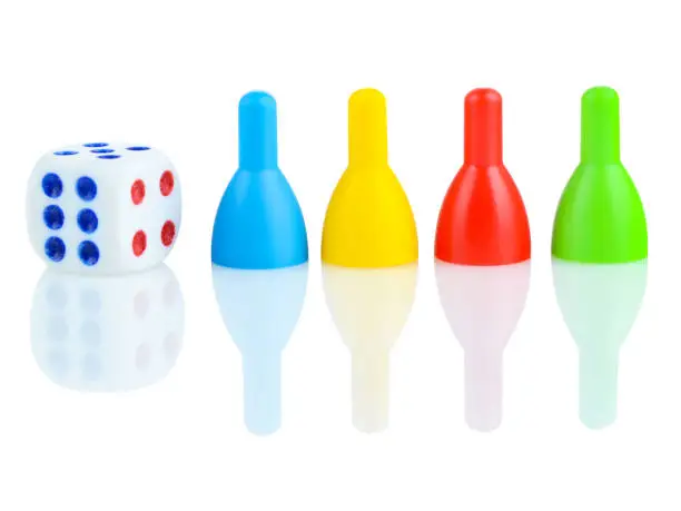 Photo of Children's dice and bowling pins in different colors on a white background. The concept of gambling. Developing thinking children's games