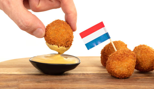 istock Dutch traditional snack bitterbal in a hand, isolated 1224956754