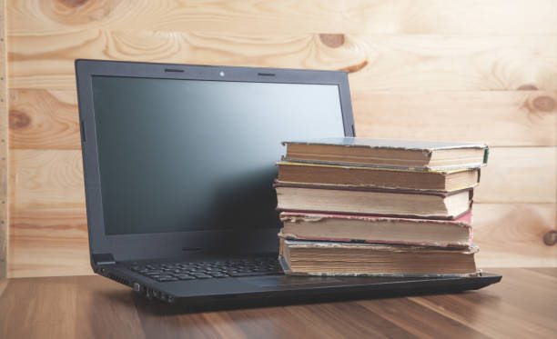 istock Books and laptop on the wooden table. 1224961075