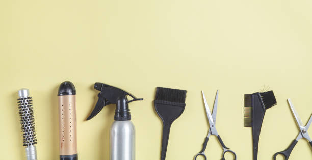 istock Scissors, comb and other hair styling tools on yellow background. 1224961085