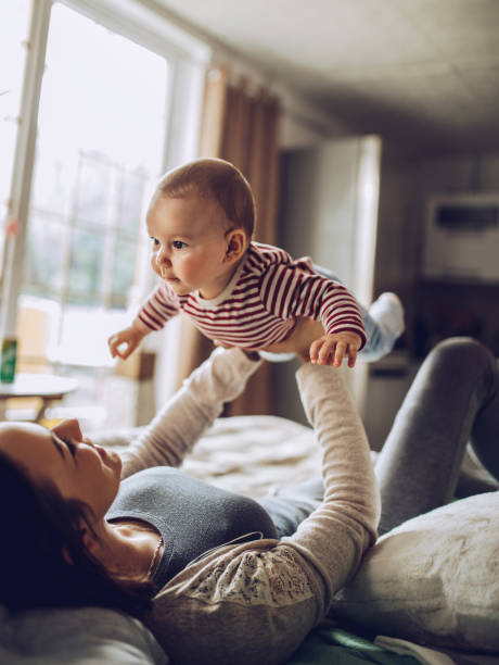 아기와 함께 침실에서 침대에 누워 행복한 젊은 가족 - baby two parent family newborn family 뉴스 사진 이미지