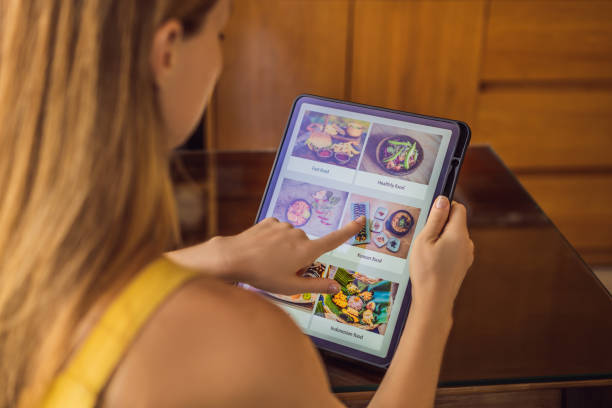 istock Young woman orders food for lunch online using Tablet 1224965642