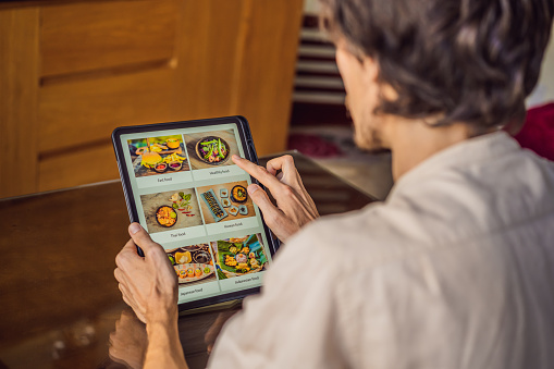man orders food for lunch online using Tablet.