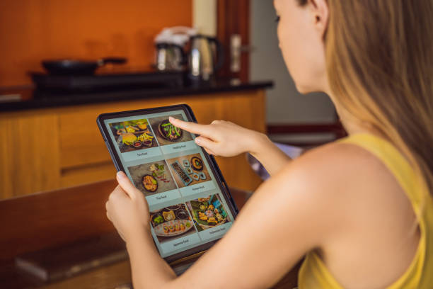 istock Young woman orders food for lunch online using Tablet 1224965647