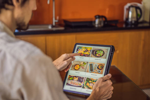 istock man orders food for lunch online using Tablet 1224965648