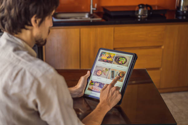 istock man orders food for lunch online using Tablet 1224965649