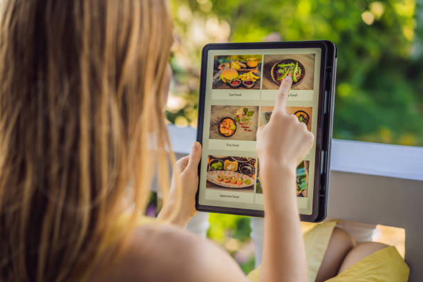istock Young woman orders food for lunch online using Tablet 1224965678
