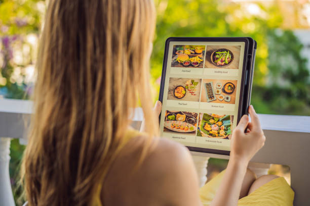 istock Young woman orders food for lunch online using Tablet 1224965680