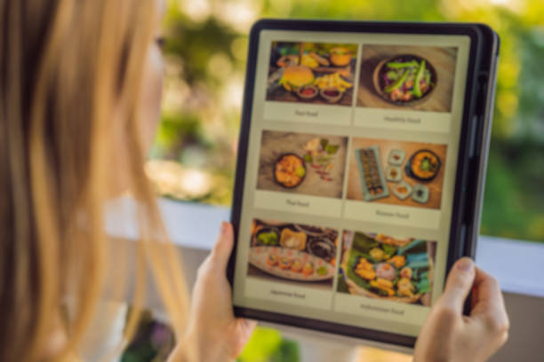 istock Young woman orders food for lunch online using Tablet 1224965681