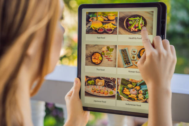 istock Young woman orders food for lunch online using Tablet 1224965687