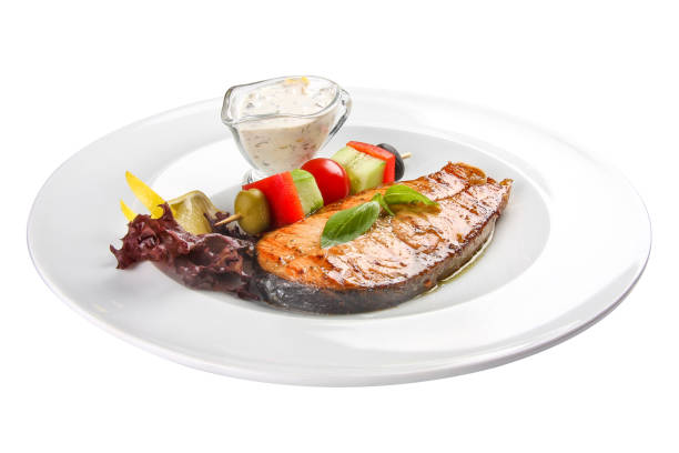 istock Salmon steak with vegetables and sauce. On a white background 1224968317