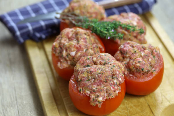 tomate relleno crudo en una mesa - stuffed tomato fotografías e imágenes de stock