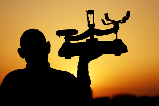 Old man of Indian Ethnicity carrying weight scale during sunset time. A balance is a device to measure weight or mass. These are also known as mass scales, weight scales, mass balances, weight balances, or simply scales, balances, or balance scales.