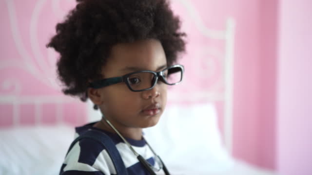African-American Ethnicity little boy tring to wearing eyeglasses and medical stethoscope