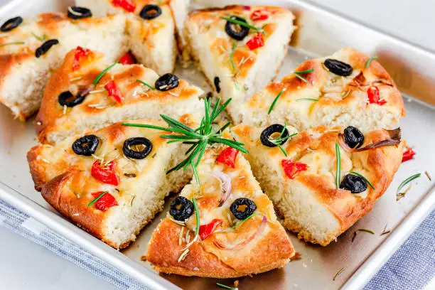 Italian focaccia bread with olives and rosemary, Close-Up Bread Slices on a Baking Tray