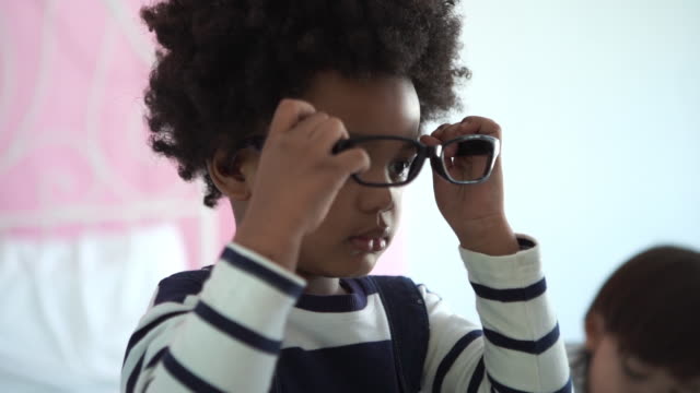 African-American Ethnicity little boy tring to wearing eyeglasses and medical stethoscope