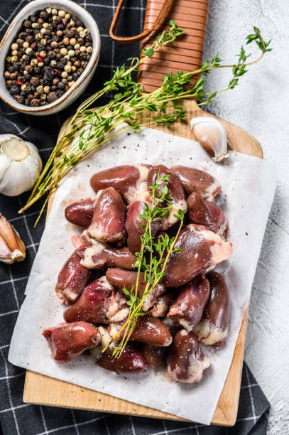 istock Raw chicken hearts on a cutting board. Organic offal. White background. Top view 1224979810