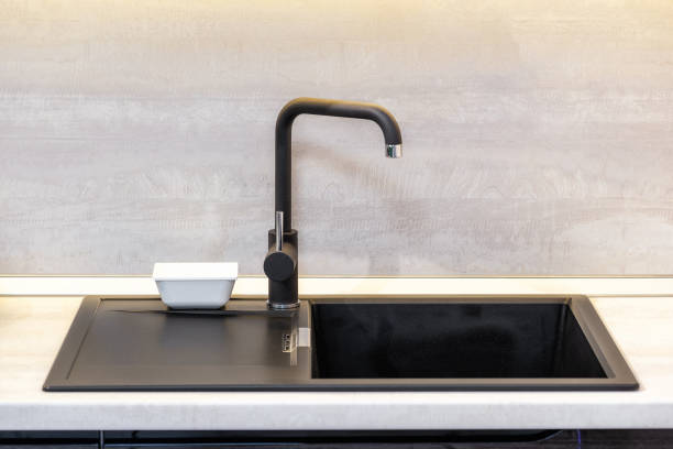 istock Black Ceramic Sink and Mixer taps on wooden worktop in kitchen room 1224979880