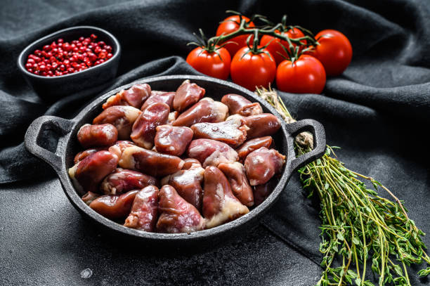 istock Fresh chicken hearts. Raw offal. Black background. Top view 1224979885