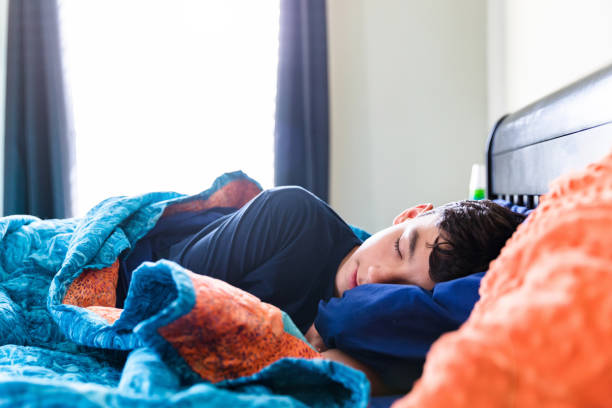Sick male teenager sleeps comfortably The sick teenage boy sleeps comfortably throughout the morning. oversleeping stock pictures, royalty-free photos & images