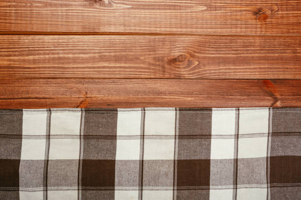 istock Top view on a dark wooden table with a linen kitchen towel or textile napkin. a tablecloth on a countertop made of old wood. Copy space for text. 1224983936