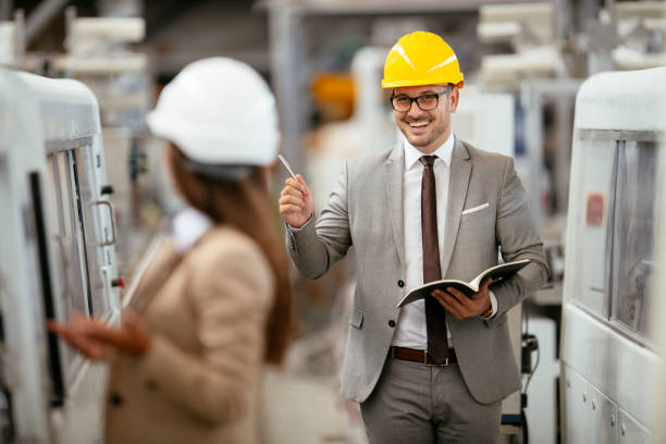 istock Two professional people with helmets working in quality control in factory production line. 1224986665