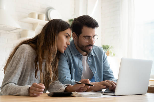 istock Focused young couple calculating bills, planning budget together 1224986965