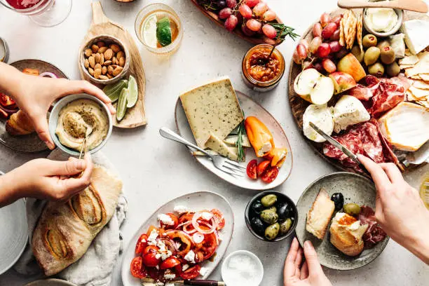 High angle view of fresh meal on table. Women are eating healthy food. They are with Mediterranean platter.