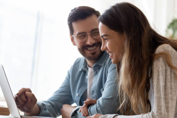 istock Happy loving couple using laptop together, holding hands 1224986978