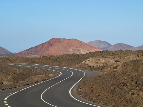 Lonely winding road through the lava fields on Lanzarote island, Spain