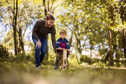 Dad is here to make his childhood more beautiful. Father teaches the son to ride a bicycle.