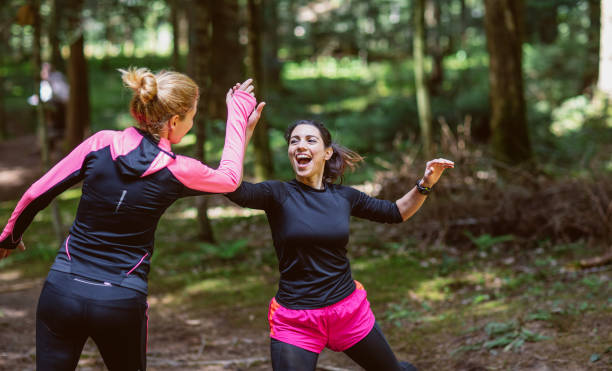 istock Two women exercising in the woods, giving high-five 1224989091
