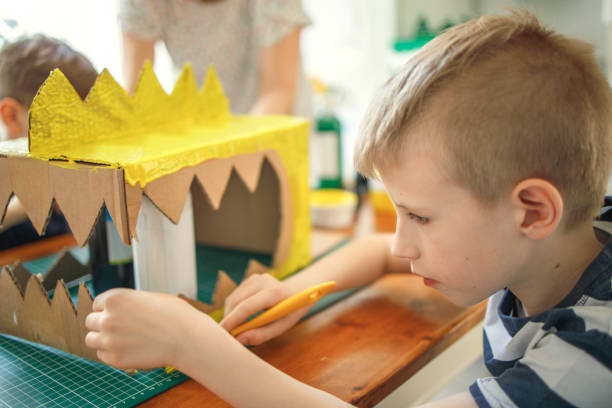 istock Brothers painting a cardboard dinosaur costume 1224989848
