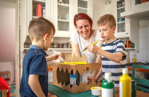 istock Mom and kids making a cardboard dinosaur costume 1224989910