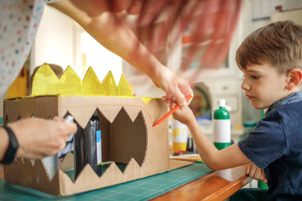 istock Mom and kids making a cardboard dinosaur costume 1224990028