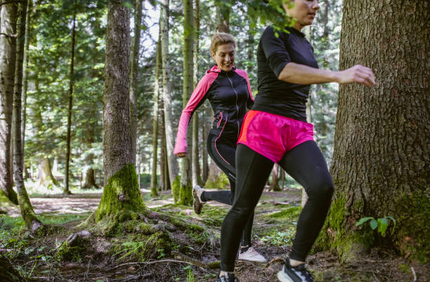 istock Two women running across the woods 1224990631