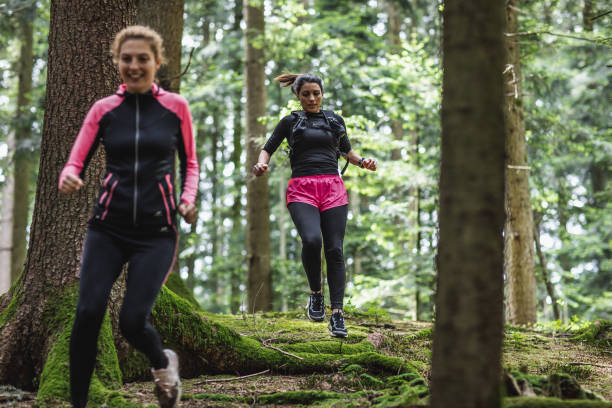 istock Two women running across the woods 1224992389