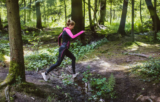 istock Woman running across the woods 1224992417