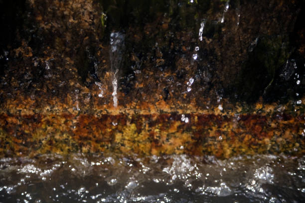 Old water fountain, spurts splashing and water surface, granite stone background. Galicia, Spain. Image suitable for background purposes.