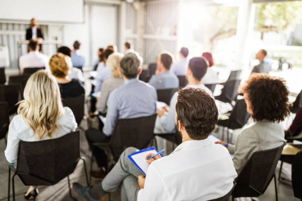 back view of large group of entrepreneurs on a seminar. - seminário imagens e fotografias de stock