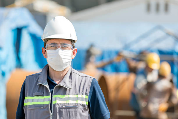 le travailleur utilise des équipements de protection individuelle. pour les professionnels de la santé qui s’occupent des personnes atteintes de covide-19, les cdc recommandent de placer la personne dans une salle d’isolement des infections aéroport - equipments photos et images de collection