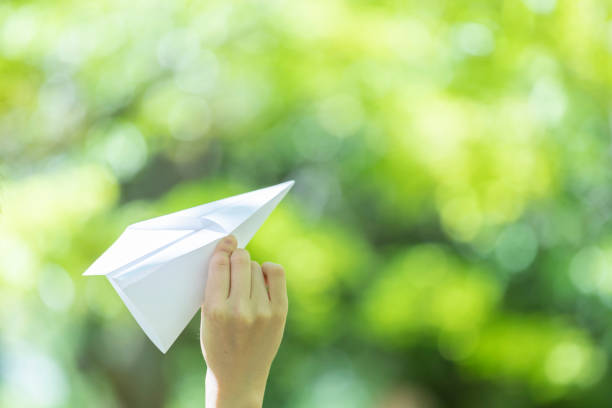 Little girl running in the park with a paper plane in her hand, heading toward her mom, reflecting the pure joy of childhood and the freedom of exploring the outdoors. Her mom watches with a loving smile, eagerly awaiting the moment to wrap her daughter in a warm hug