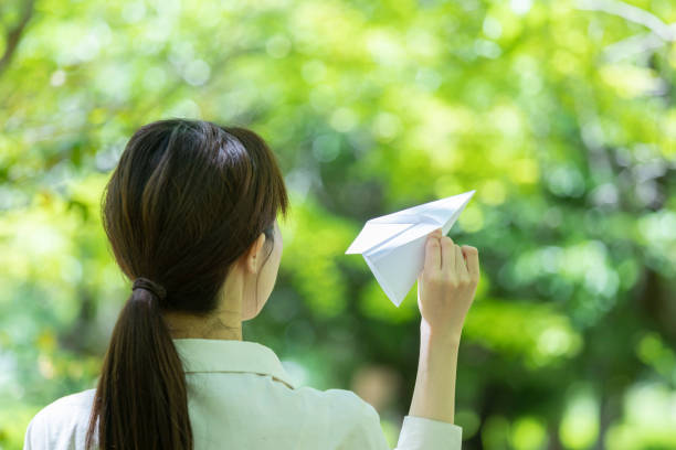 istock Young woman lady with handmade paper plane 1225001299