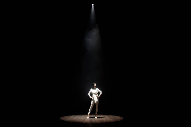 modello in un abito bianco sul palco in un fascio di luce bianca - popular music concert lighting equipment illuminated stage foto e immagini stock