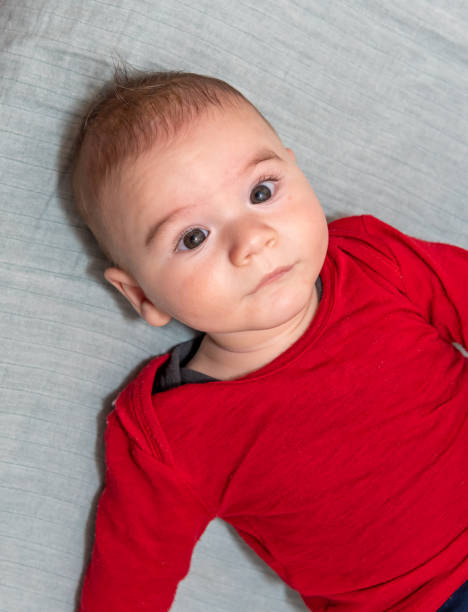 istock Adorable 6 months old little baby boy on his back looking up 1225002034