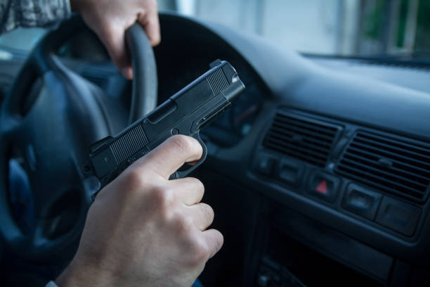 robbery Man in black balaclava with handgun driving a car. gunman photos stock pictures, royalty-free photos & images