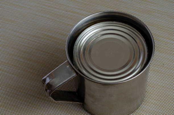istock Steel mug and tin can on a textured background. 1225002114