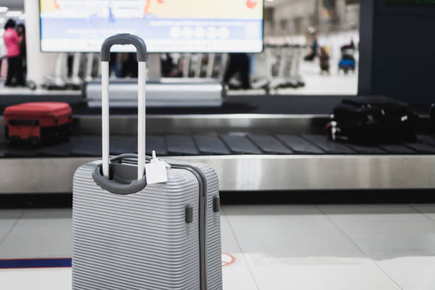 istock Luggage holder suitcase or baggage with Tag blank label for display your products for traveling luggages near blur convey belt in airport departure terminal background, Transport trip vacation concept 1225002323