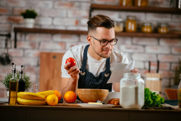 istock Handsome man making delicious food in kitchen. 1225002552